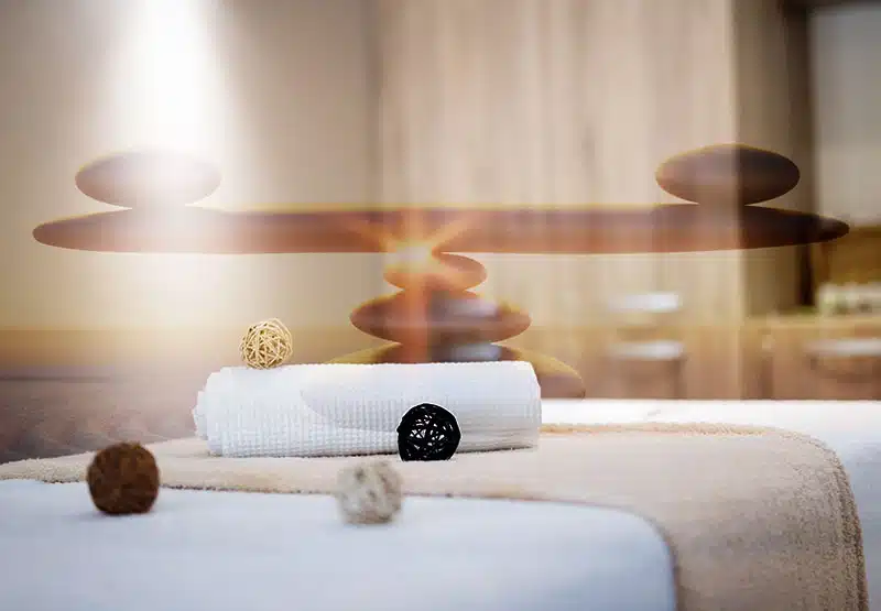 reiki-hynose800-1 Steine die als Balancesymbol liegen, eine Reikiliege mit Handtüchern